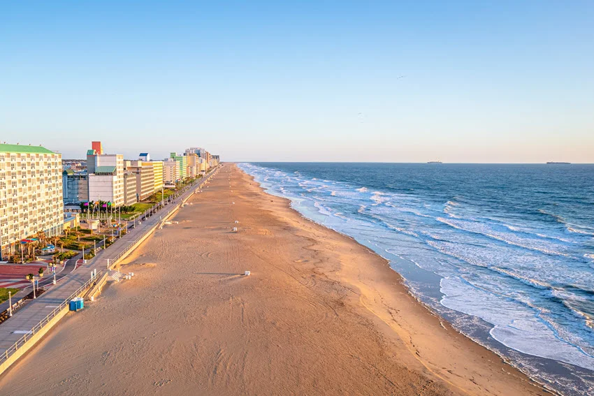 Elevated view of a long Atlantic coastline with beachfront hotels and open surf, a strong destination visual for coastal fishing access and offshore trip planning.