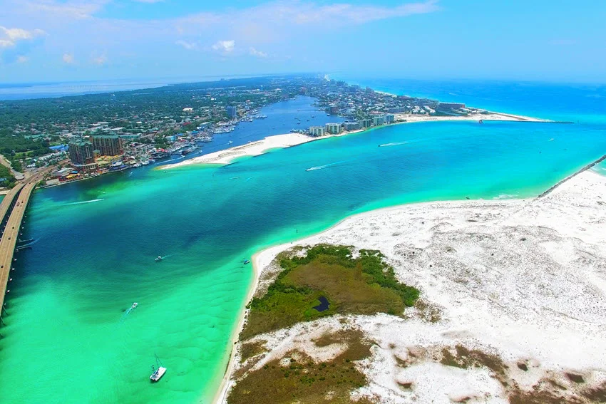 Aerial view of Destin, Florida, with bright emerald water, coastal inlets, and easy offshore access, one of the best-known Gulf Coast areas for Amberjack fishing trips.