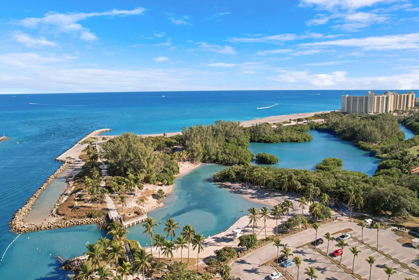 Aerial view of a South Florida inlet, protected water, and nearby open coast, a strong location visual for discussing offshore access and productive Amberjack fishing areas.