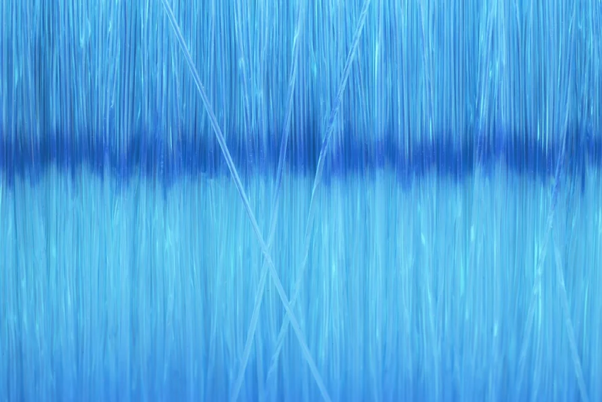 Macro view of thin fishing line strands forming a blue pattern, with overlapping lengths and soft highlights visible across the frame.
