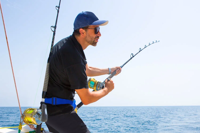Angler fighting a strong Grouper offshore with heavy tackle and a bent rod, showing the power of this hard-pulling reef fish.