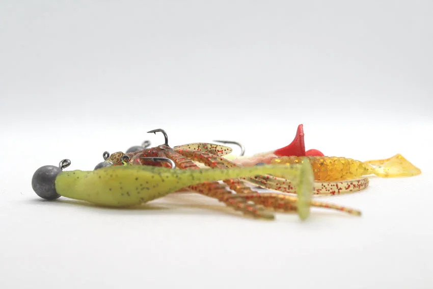 Soft plastic lures rigged for saltwater fishing, showing versatile bait options for working reefs, ledges, and other Grouper structure.