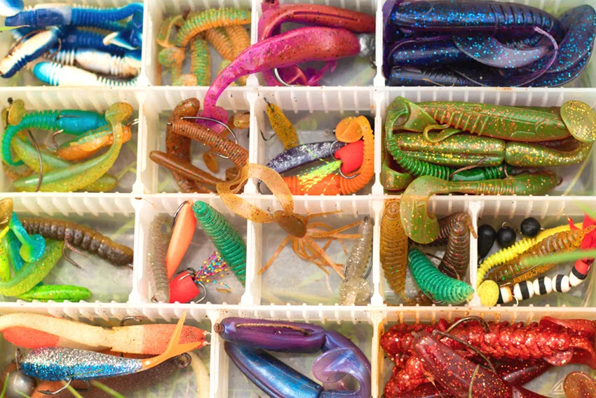 Colorful soft plastic lures arranged inside a tackle box, illustrating versatile artificial bait options for King Mackerel fishing.