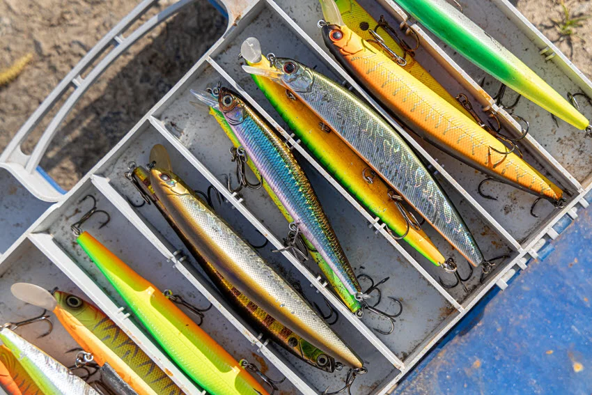 Detailed close-up of a hard-bodied plug fishing lure, showing vibrant colors, realistic patterns, and hooks, designed to attract predatory fish.