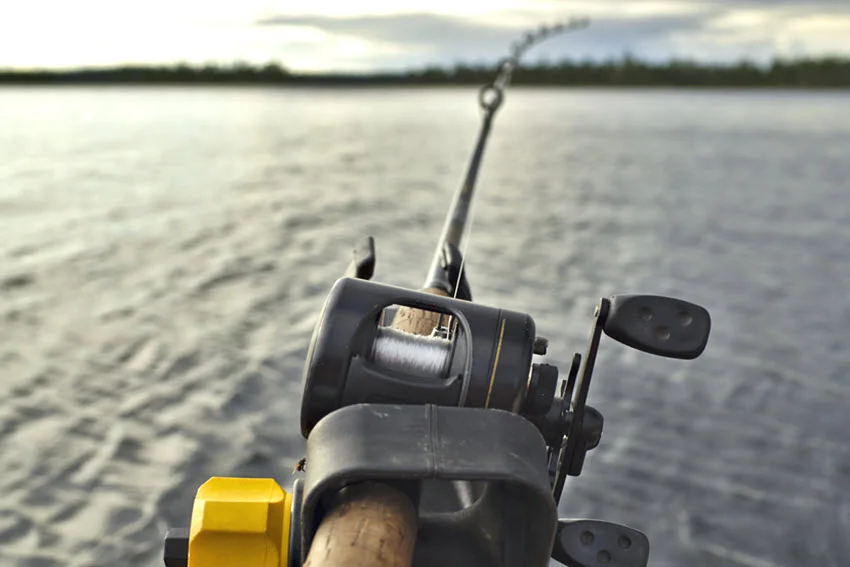 Close view of a trolling rod and reel setup used for Northern Pike fishing on open water.