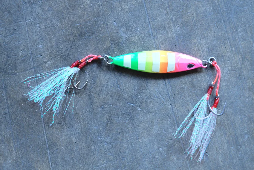Bright metal jig with assist hooks, showing a flashy lure option anglers use for Salmon when jigging or working deeper coastal water.