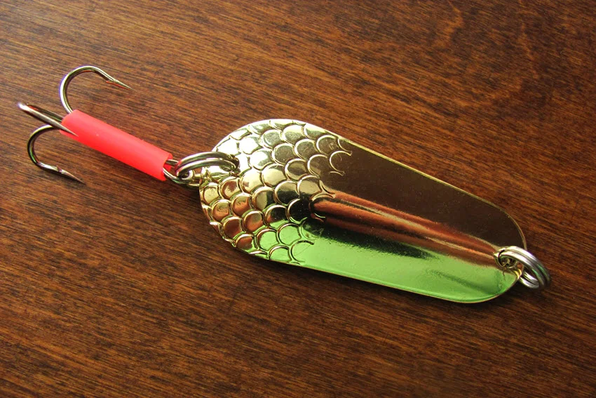 Shiny metal spoon lure with a treble hook, showing a classic Salmon lure used to create flash, vibration, and movement in rivers and coastal water.