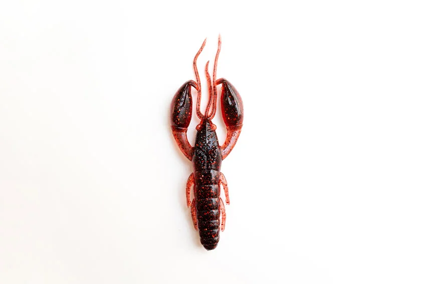 Bright red plastic crab bait positioned on a clean white surface with detailed textures visible.