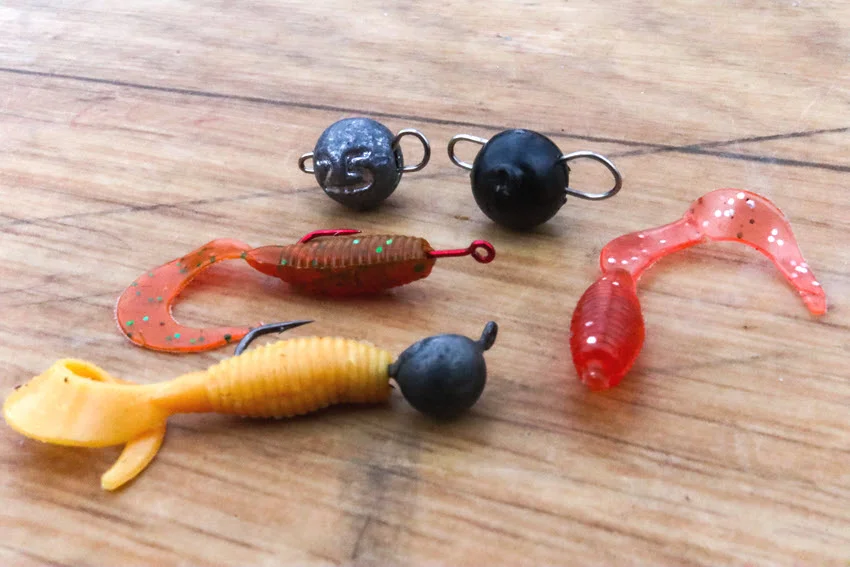 Close view of colorful soft-plastic grubs paired with weighted jig heads for presenting small artificial baits to feeding Sheepshead.