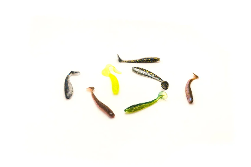 Assorted soft plastic paddle-tail baits in different colors displayed on a white background.