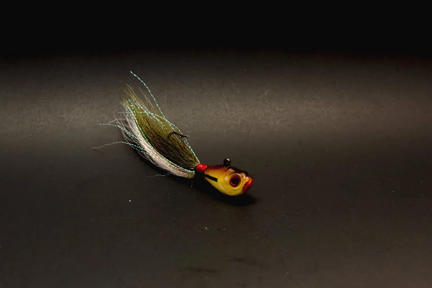 Hand-tied bucktail jig with deer hair and flash, showing a proven Snook lure for fishing current, bridge edges, and ambush points.