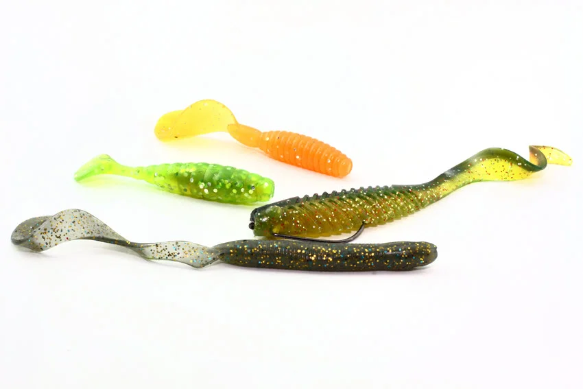 Soft plastic paddle tails and curly tail baits on a white background, showing versatile lure choices for Snook in shallow water, channels, and moving current.
