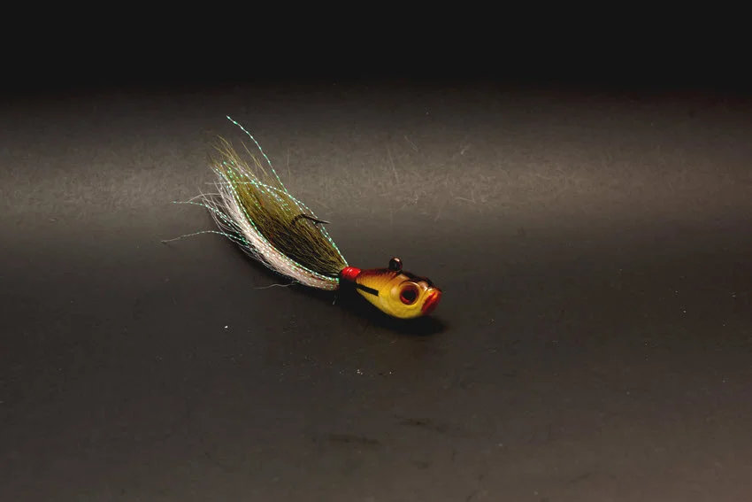 Focused shot of a compact bucktail jig with reflective fibers, a versatile lure for casting and vertical jigging for Spanish Mackerel.
