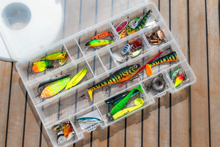 Top down view of organized fishing tackle box filled with various fishing lures.