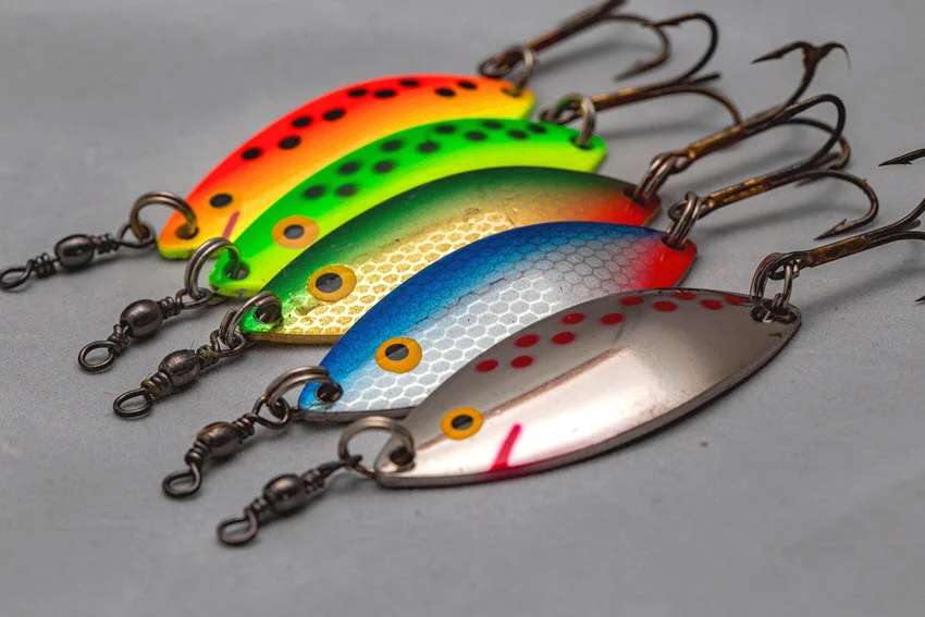 Close-up of a selection of different colors of metal fishing lures used to catch a whole range of predatory fish, including Trout.
