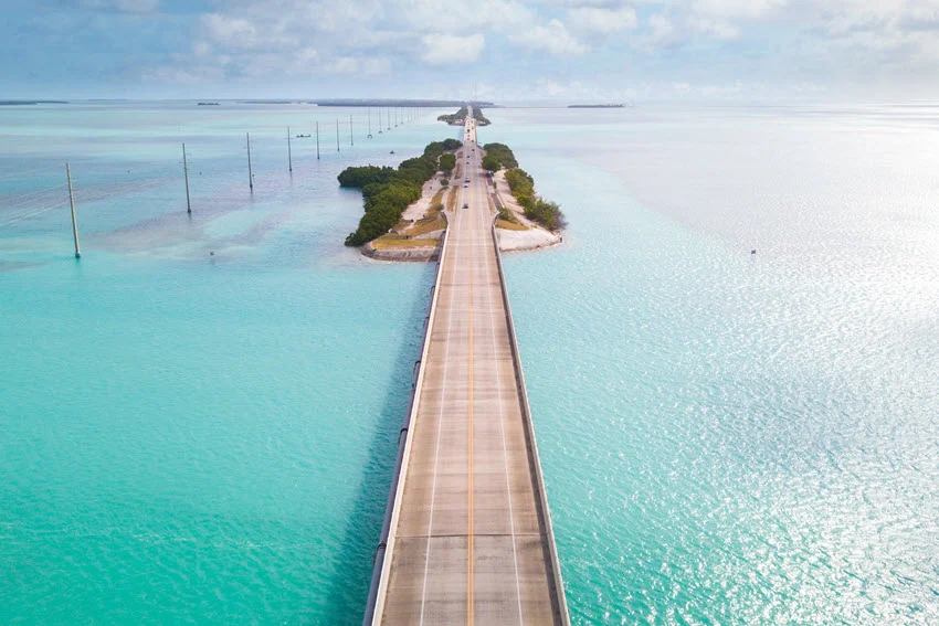 Long bridge stretching across bright turquoise water in the Florida Keys, a well-known area for saltwater fishing and coastal travel.
