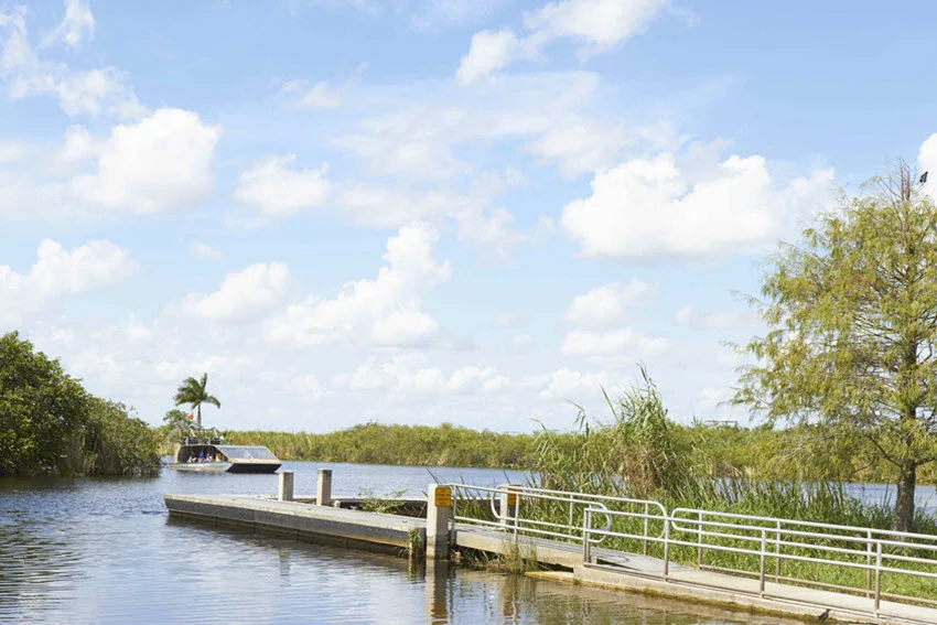 Boat coming to the pier and a mini dock in Holiday Park in Everglades.