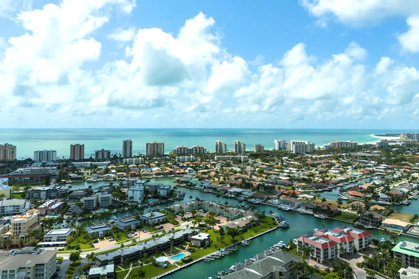 Aerial view of Marco Island's coastline off the Gulf of Mexico in Southwest Florida. The image captures the island's sandy beaches, clear turquoise waters, and lush greenery, showcasing the natural beauty of this coastal paradise.