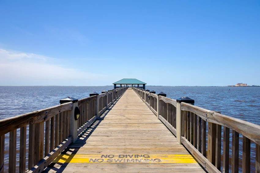 A serene Gulf Coast beach in Ocean Springs, Mississippi, with soft sand, gentle waves, and a peaceful shoreline.