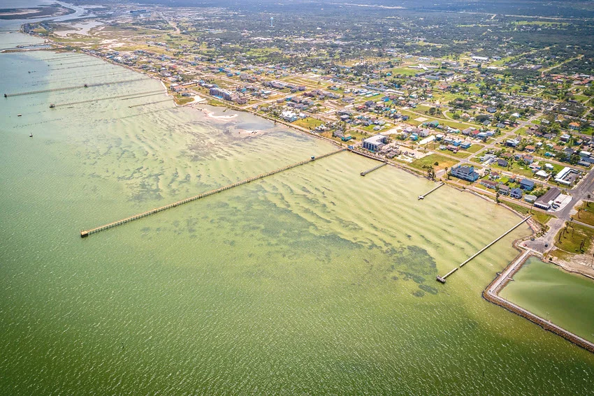 Scenic piers in Rockport, Texas, extending into the calm waters of the bay. The piers are surrounded by gentle waves and a peaceful coastal atmosphere, perfect for fishing and enjoying the natural beauty of the area.