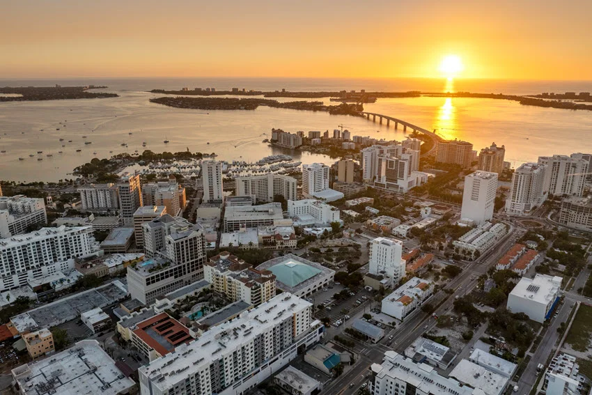 Downtown Sarasota, Florida at sunset with waterfront high-rises and colorful reflections highlighting the city's upscale coastal charm.