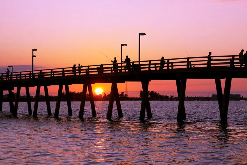 Sunset at the fishing pier in Sarasota, Florida, with the vibrant colors of the setting sun casting a warm glow over the water.