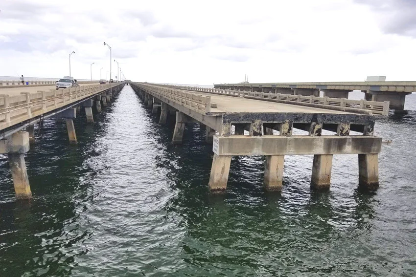 View of a fishing pier in St. Petersburg, Florida, with overcast clouds creating a dramatic sky above the tranquil coastal waters.