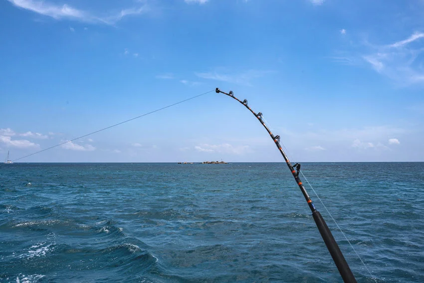 View of a trolling rod placed on a moving fishing boat.