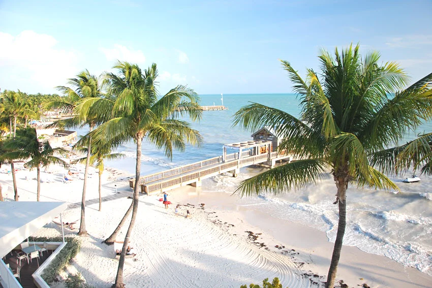 Scenic beach along the Atlantic Ocean in Key West, featuring clear turquoise water, bright skies, and a peaceful tropical shoreline.