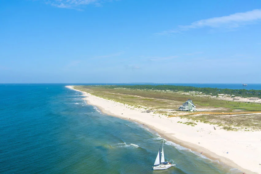 Aerial view of Fort Morgan with its historic fortifications and a long sandy beach stretching along the coastline.