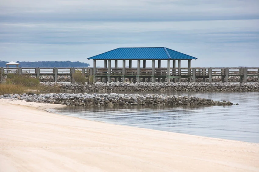 View from the beach of a beautiful private dock extending into Biloxi Bay.