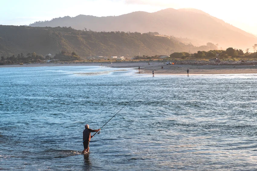 Distant view of an angler standing in shallow water, focused on sight fishing with clear visibility and calm surroundings.