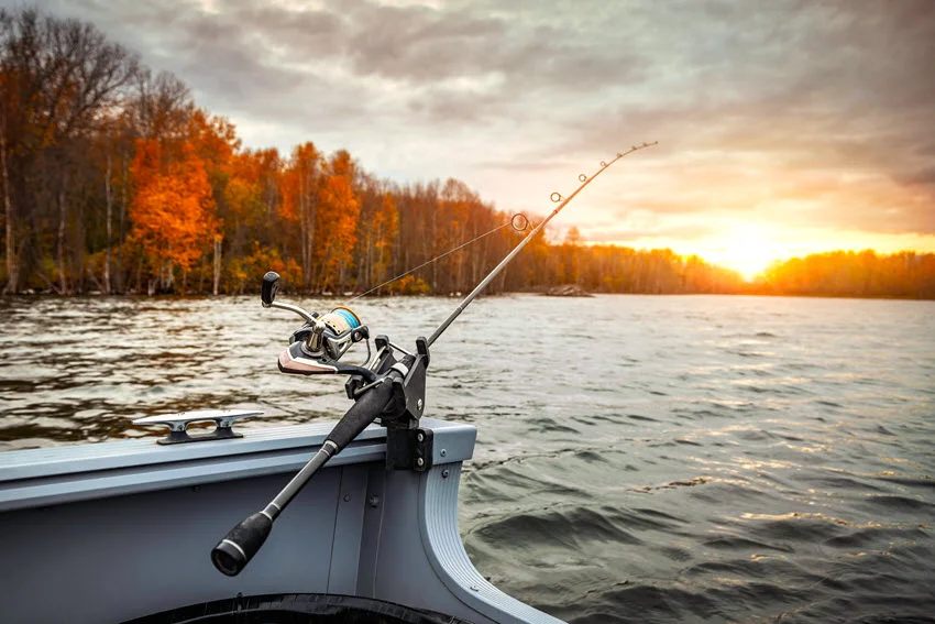 Fishing rod secured on a boat at sunset, illustrating a quiet low-light approach to Peacock Bass fishing on open water.
