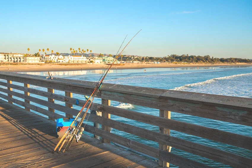 Fishing rods set up on a pier at sunset, ready for the next catch. A tranquil and picturesque fishing scene by the water.