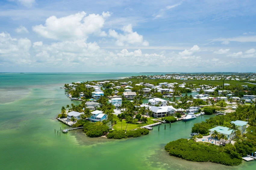 Aerial view of waterfront homes and shallow turquoise channels across the Florida Keys, a prominent destination for coastal Shark fishing.