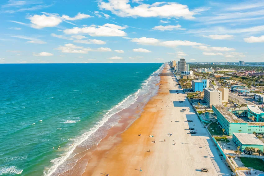 Aerial view of Daytona Beach, Florida, with wide surf, sandy shoreline, and nearshore Atlantic water often associated with coastal shark fishing.