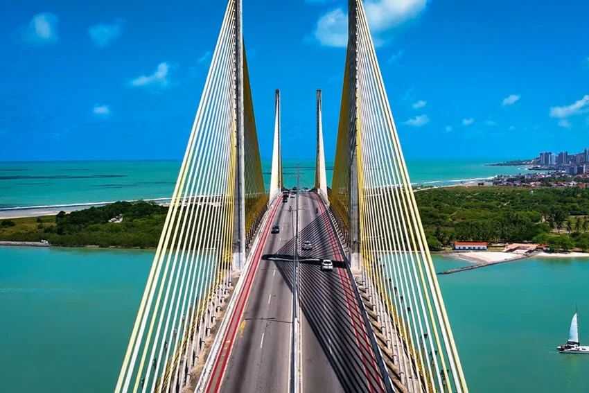 Aerial view of the Sunshine Skyway Bridge spanning Tampa Bay, with turquoise water, cable stays, and a bright blue sky on a clear day.