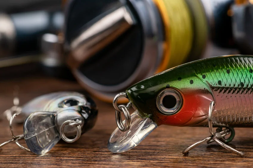 Close shot of crankbait fishing lures arranged on a wooden surface.