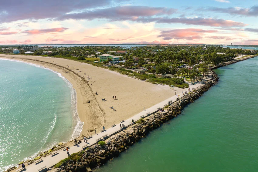 Aerial view of the Fort Pierce area inlet jetty and rocky shoreline, highlighting moving water, structure, and current seams that concentrate bait.
