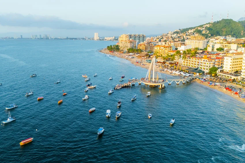 Aerial shot of a Mexico waterfront harbor with boats and seawalls, showing protected water, docks, and edges that shape inshore fishing zones.