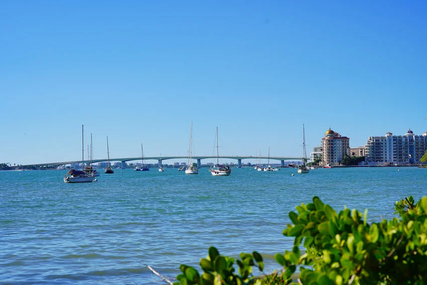 Tampa Bay area coastal view with a long bridge, boats, and open water, showing a wide current corridor and structure lines anglers fish around.