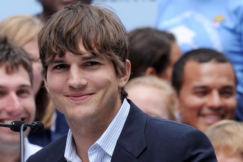 Ashton Kutcher at the press conference of the Entertainment industry foundation, with a soft smile and a distinctive hairstyle.