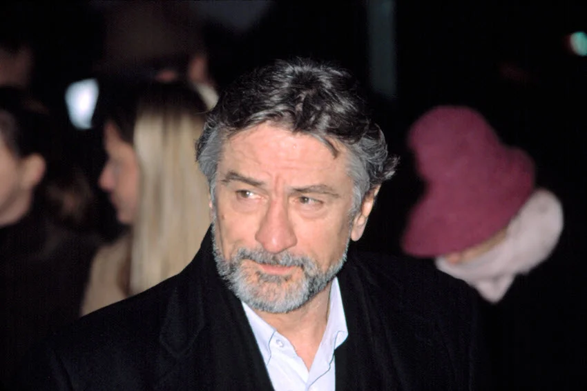 Robert de Niro at the promotion of the film "Analyze That," under the lights of cameras, surrounded by colleagues.