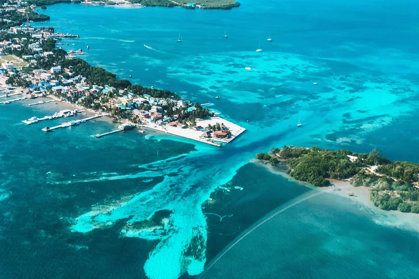 Aerial view of Caye Caulker, Belize, showcasing the island’s turquoise waters, sandy shores, and lush vegetation, a popular destination in the Caribbean Sea.