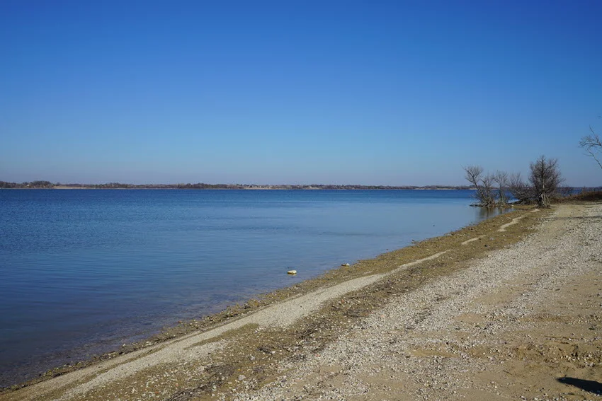 Lake Fork's sandy shore and calm water early in the morning.