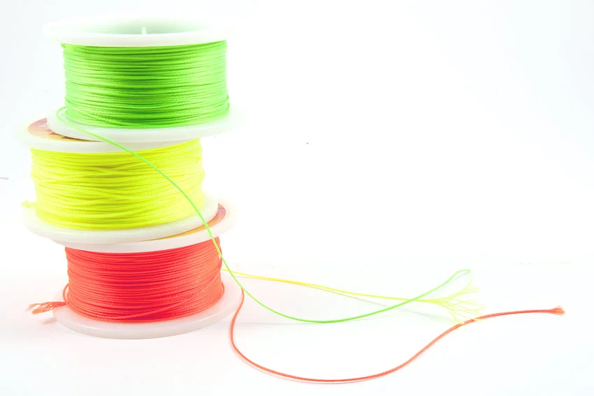 Studio close-up shot of three spools of braided fishing line, neatly arranged to showcase their texture and durability.