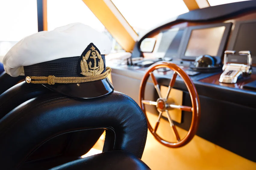 Captain's fishing charter cap on a seat next to the boat's helm.